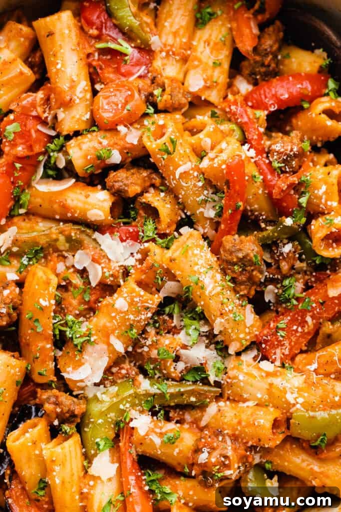 A close-up of the rigatoni with roasted peppers and tomatoes, highlighting the rich, creamy sauce and perfectly cooked Italian sausage.