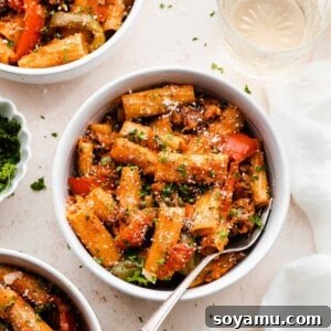 Bowls of the rigatoni pasta topped with fresh parsley and parmesan, showcasing a vibrant and hearty Italian dinner.