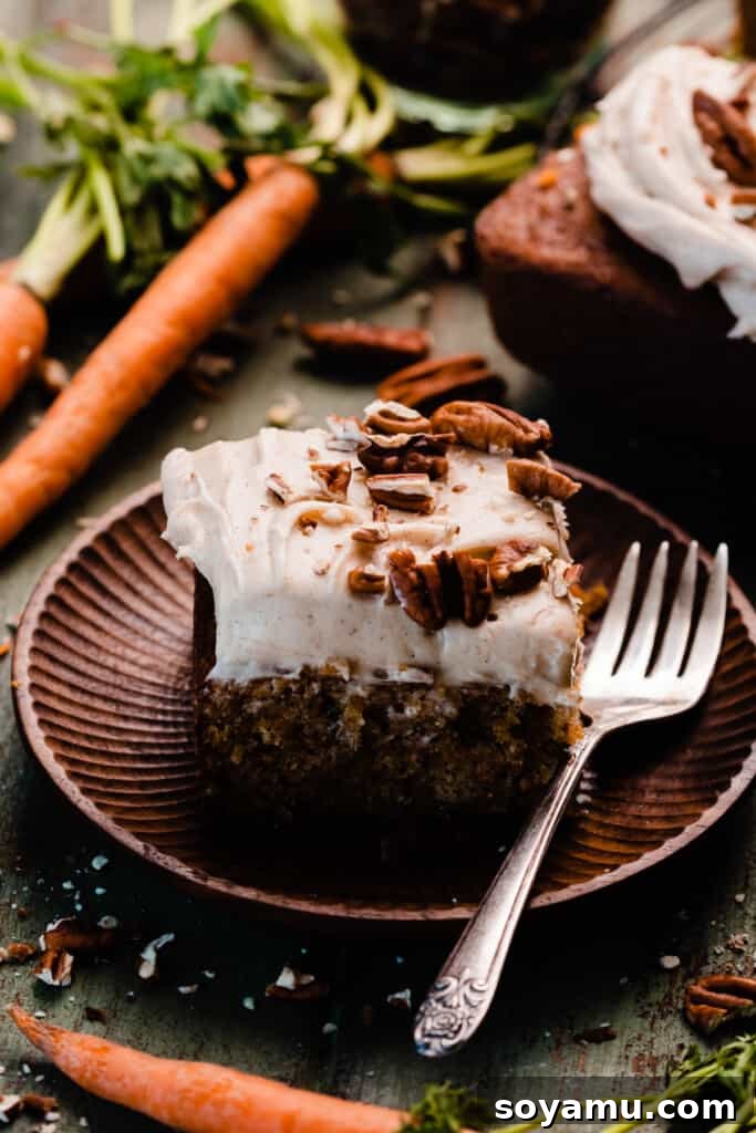 Caramelized Brown Butter Mini Carrot Cakes 11 A beautifully frosted slice of mini carrot cake, presented on a delicate cake plate, ready to be enjoyed.