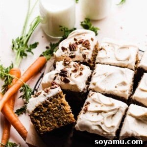 The carrot cake frosted and sliced, with crushed pecans on top.