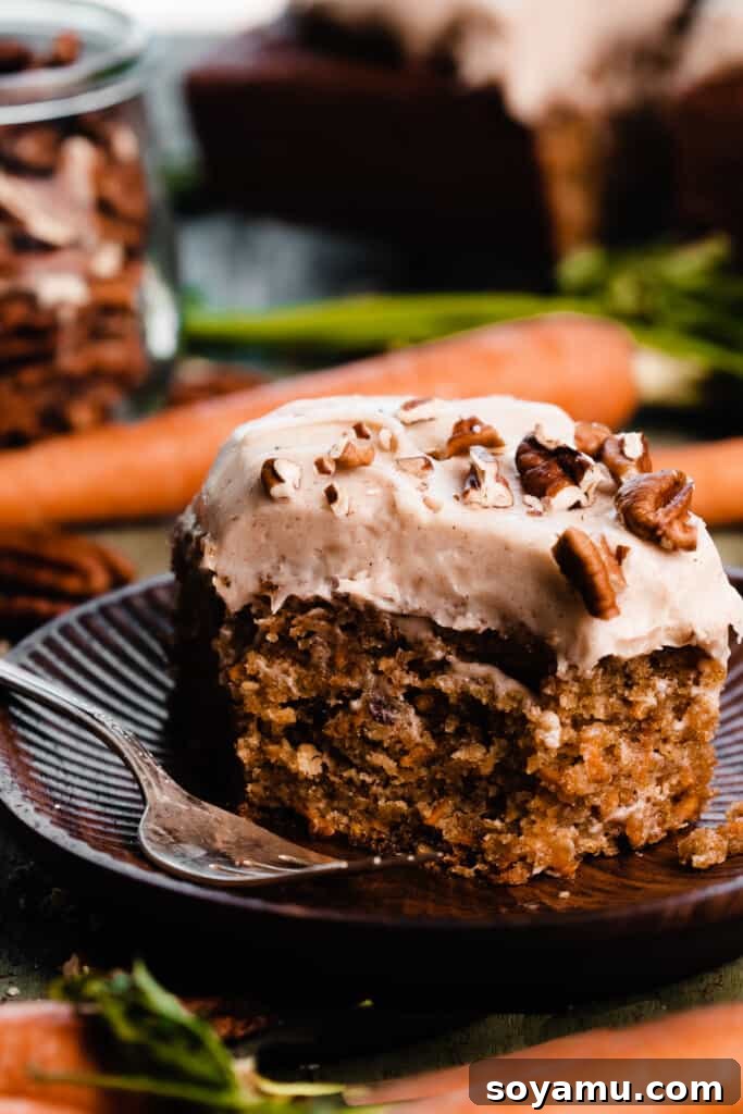 Caramelized Brown Butter Mini Carrot Cakes 3 A perfectly portioned slice of mini carrot cake, showcasing its moist interior and creamy frosting, with a small bite taken out, resting on a white plate.
