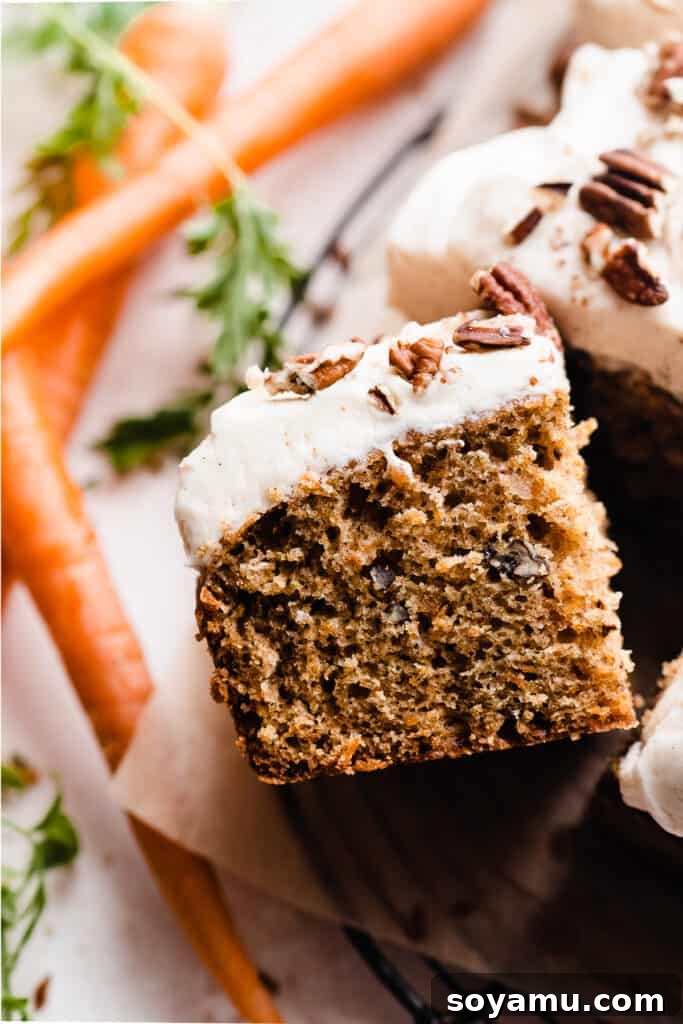Caramelized Brown Butter Mini Carrot Cakes 4 A close-up shot of a slice of carrot cake, highlighting the rich, moist cake layers and the thick, creamy brown butter cream cheese frosting cascading over the edges.