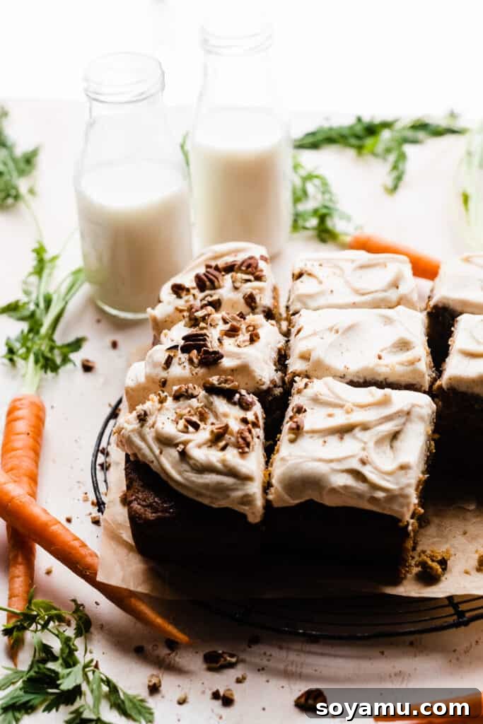 Caramelized Brown Butter Mini Carrot Cakes 10 A straight-on view of the perfectly sliced carrot cake, adorned with frosting and pecans, presented with fresh carrots and bottles of milk nearby, ready for serving.