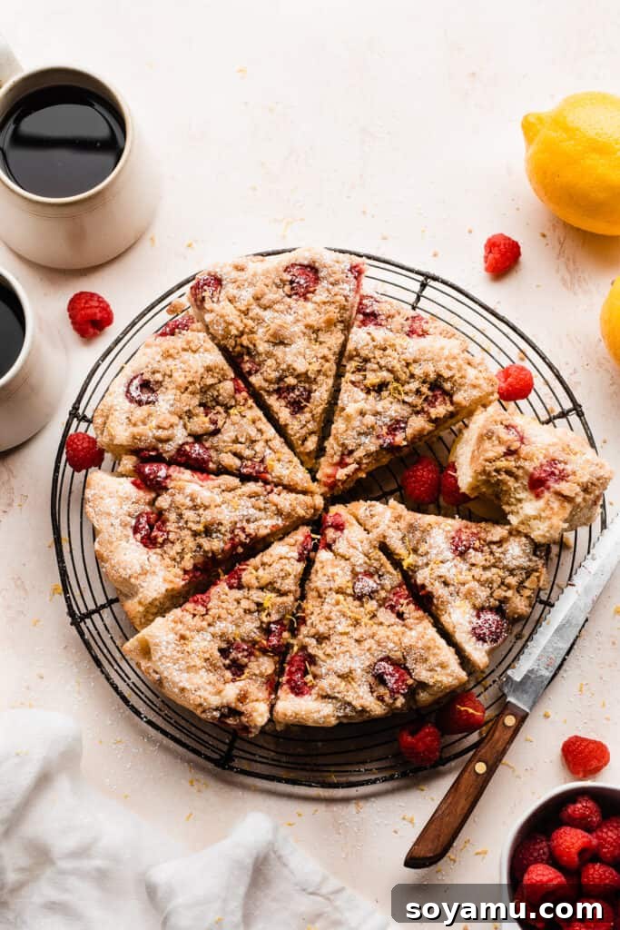 Zesty One-Bowl Raspberry Lemon Coffee Cake 11 Sliced crumb cake on a cooling rack, with cups of coffee and fresh raspberries.