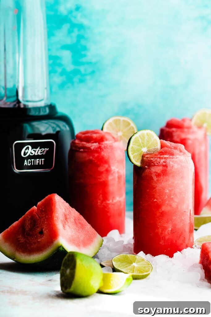 Watermelon Wave Frozen Margaritas 8 Three glasses of watermelon margaritas with a blender in the background.