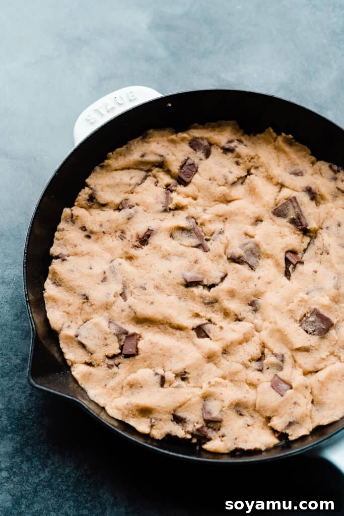 Gooey S'mores Skillet Cookie 6 Half the cookie dough pressed firmly into a cast iron skillet, forming the base layer.