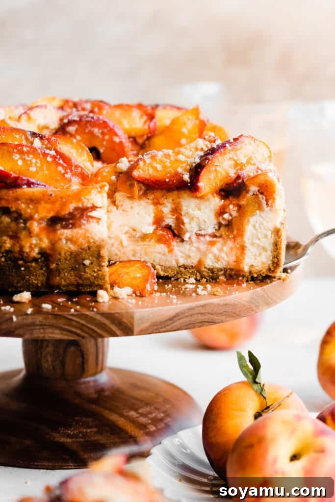 A straight-on view of the inside of the peach cobbler cheesecake, showcasing the generous layers of juicy peaches and cinnamon streusel within the creamy cheesecake.
