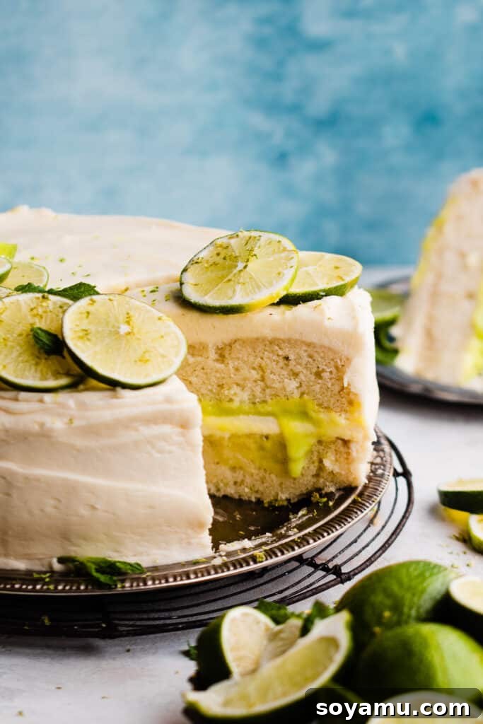 Zesty Mojito Cake with Spiked Rum Buttercream 11 A close-up on a slice of mojito cake on the cake plate, with visible lime curd and vanilla frosting in the middle.