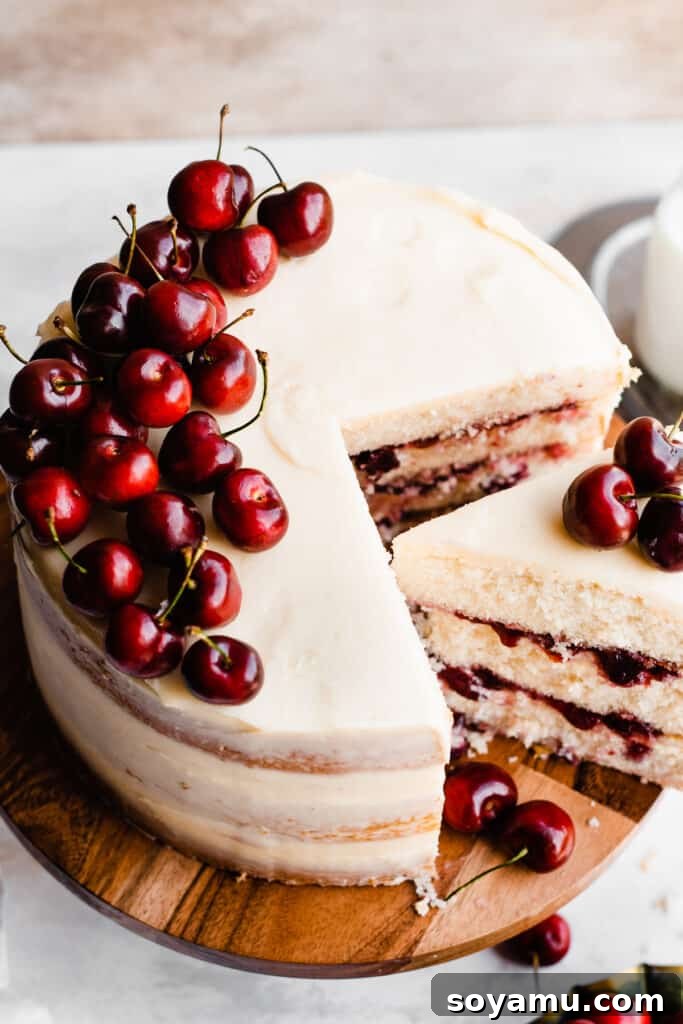 Enchanted White Forest Cake 11 A top-down view of the elegant White Forest Cake, beautifully garnished with a generous pile of fresh, vibrant cherries.