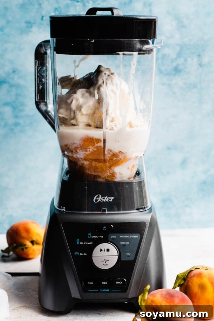 Swirled Homemade Peach Pie Milkshake 5 A blender carafe filled with milk, generous scoops of creamy vanilla ice cream, and a rich, golden homemade peach pie filling, perfectly arranged and ready for blending.