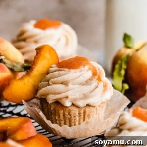 Peach cupcakes topped with frosting and peach filling.