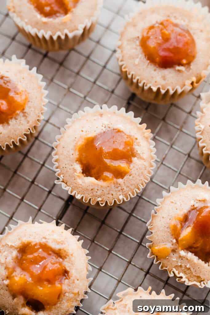 Luscious Peach Cupcakes Crowned with Cinnamon Cream Cheese Frosting 9 Close-up view of several cupcakes, showing how they are carefully filled with the peach pie filling before frosting.