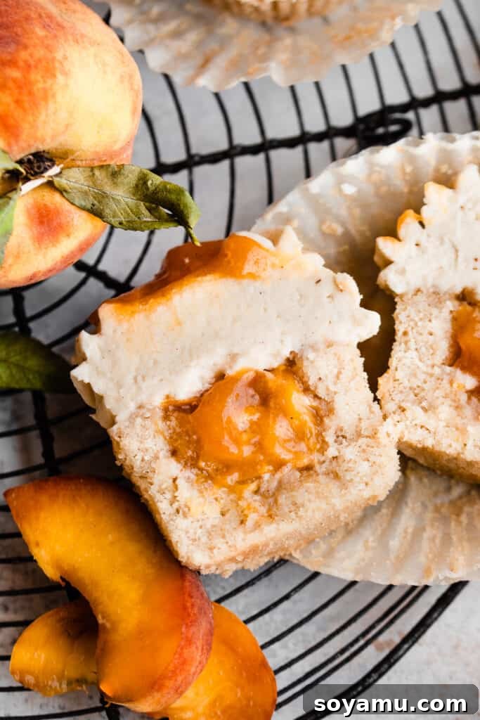 Luscious Peach Cupcakes Crowned with Cinnamon Cream Cheese Frosting 10 A close-up, top-down view of a peach cupcake cut in half, revealing the generous layer of homemade peach pie filling within.