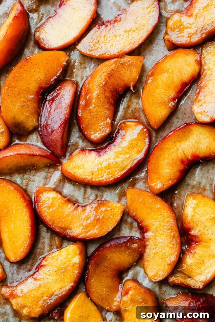 Caramelized Cinnamon Peaches 6 Freshly roasted, juicy peach slices on a sheet pan, still warm from the oven and glistening with syrup.