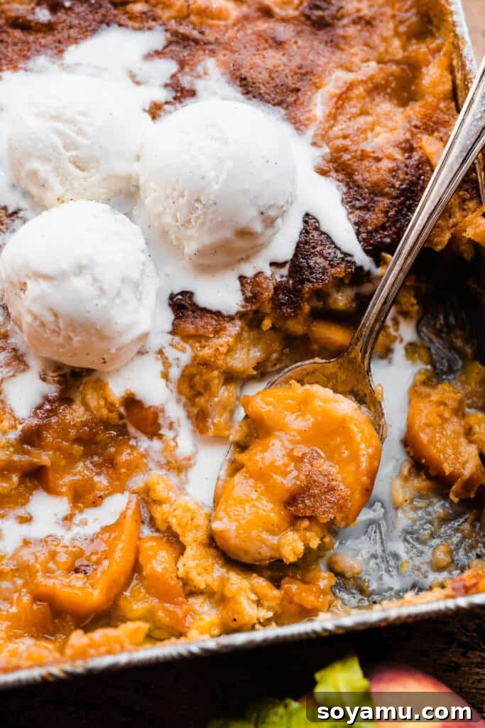 Easy Peachy Cobbler Bake 3 A close-up of a serving spoon scooping into the cobbler.