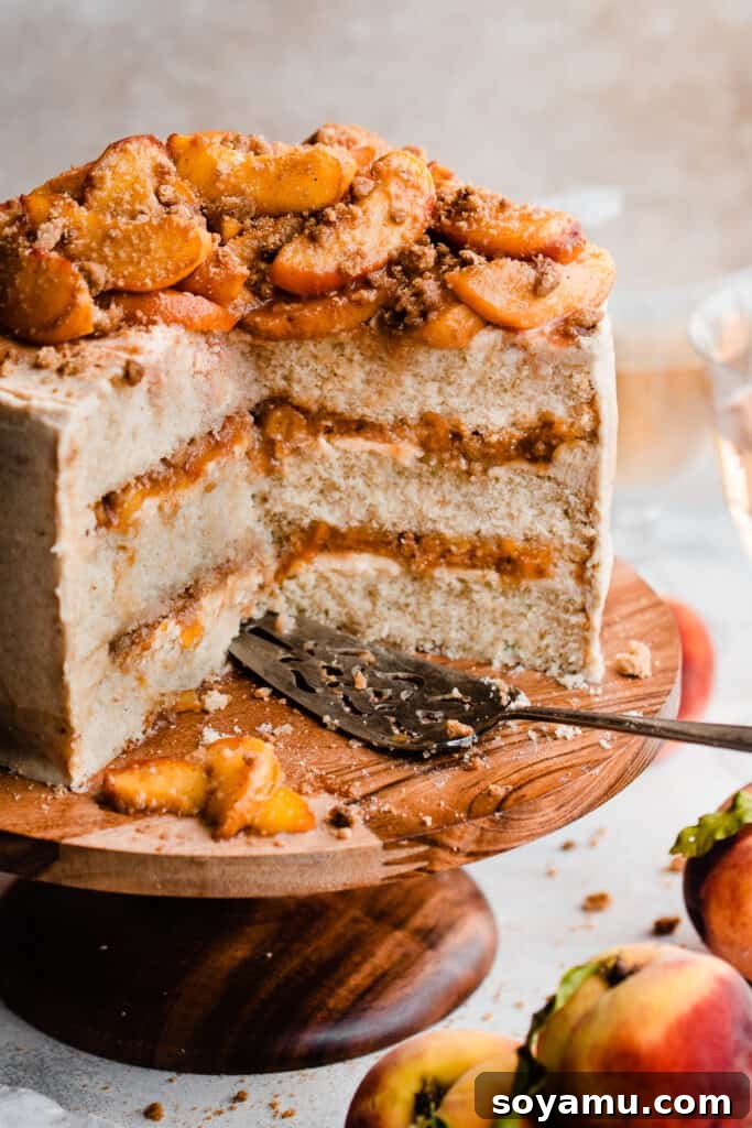 Golden Peach Cobbler Cake with Nutty Brown Butter Frosting 13 A perfectly sliced peach cobbler cake on a cake stand, with a cake server ready to dish out portions.