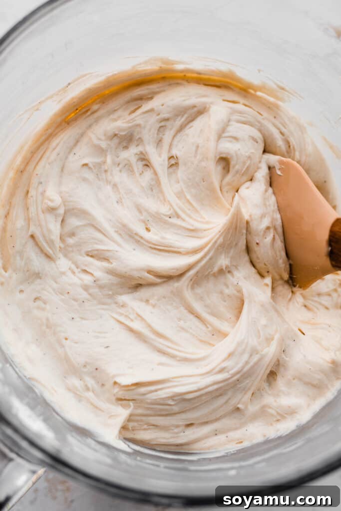 Golden Peach Cobbler Cake with Nutty Brown Butter Frosting 8 A large bowl filled with creamy, light brown butter frosting, ready for cake assembly.