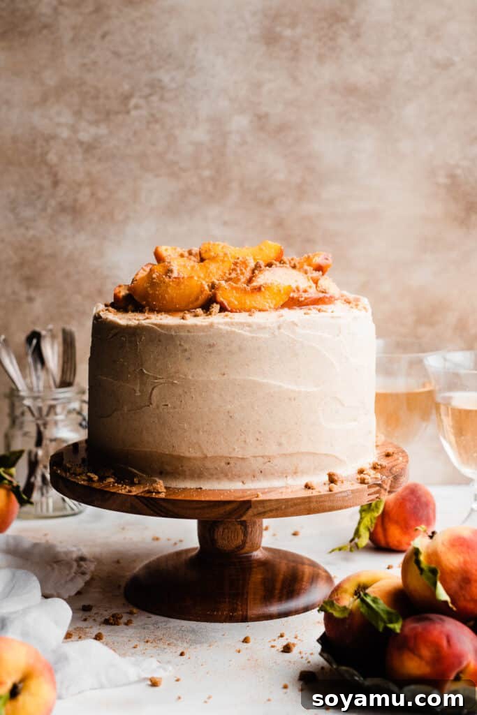 Golden Peach Cobbler Cake with Nutty Brown Butter Frosting 10 The fully frosted peach cobbler cake, elegantly presented on a cake stand, topped with roasted peach slices.