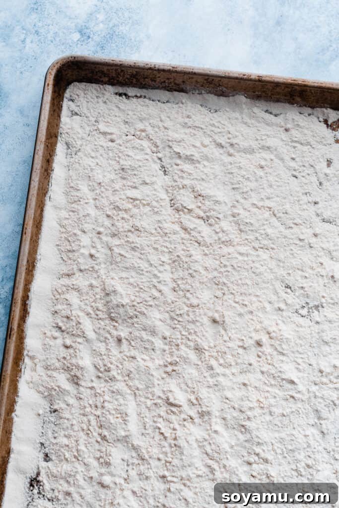 No-Bake Cookie Dough Poppers 4 A baking tray with a thin, even layer of all-purpose flour, ready for heat treatment.