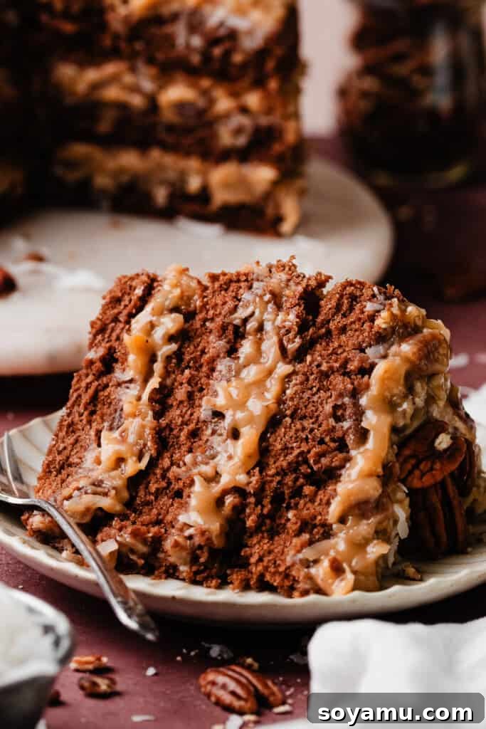 A slice of German Chocolate Cake lying gently on a cake plate, inviting a bite.