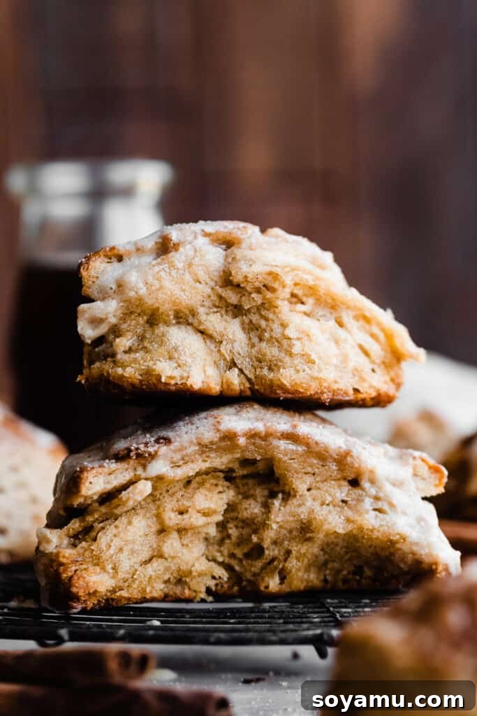 Warm Maple Biscuits with a Velvety Maple Glaze 3 A golden-brown maple biscuit broken in half, revealing its incredibly flaky, soft, and fluffy interior layers.