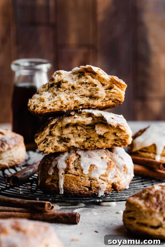 Warm Maple Biscuits with a Velvety Maple Glaze 10 A stack of three golden maple biscuits, with two broken open to reveal their inviting, flaky layers and tender crumb.