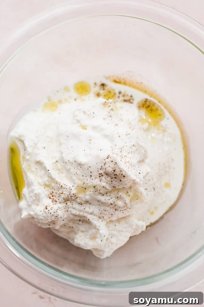 Luscious Fig & Honey Ricotta Toast 4 A bowl containing fresh ricotta cheese, olive oil, heavy cream, salt, and pepper, ready to be whipped.
