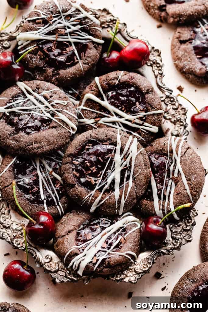 Midnight Forest Cherry Cookies 2 A vintage metal tray filled with freshly baked Black Forest Cookies, beautifully topped with white chocolate drizzles and delicate chocolate shavings, inviting a delightful indulgence.