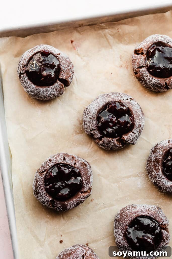 Midnight Forest Cherry Cookies 5 A tray of unbaked Black Forest Cookies, perfectly shaped with cherry preserves nestled in their centers, ready to be transformed in the oven.