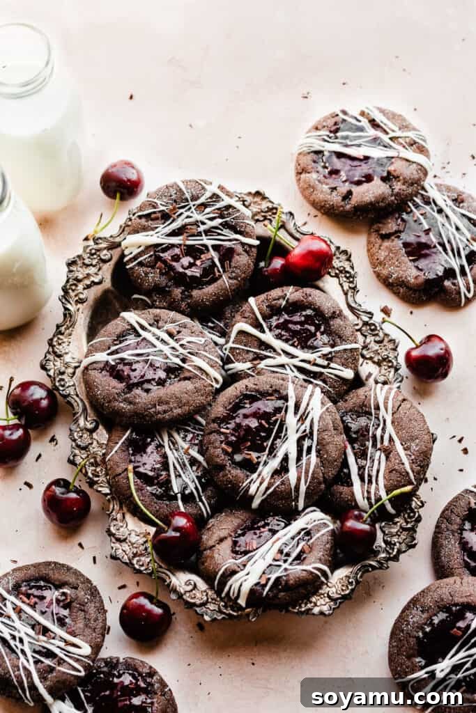 Midnight Forest Cherry Cookies 8 A vintage metal tray filled with finished Black Forest Cookies, adorned with white chocolate, surrounded by fresh cherries and two small bottles of milk, creating a rustic and inviting scene.