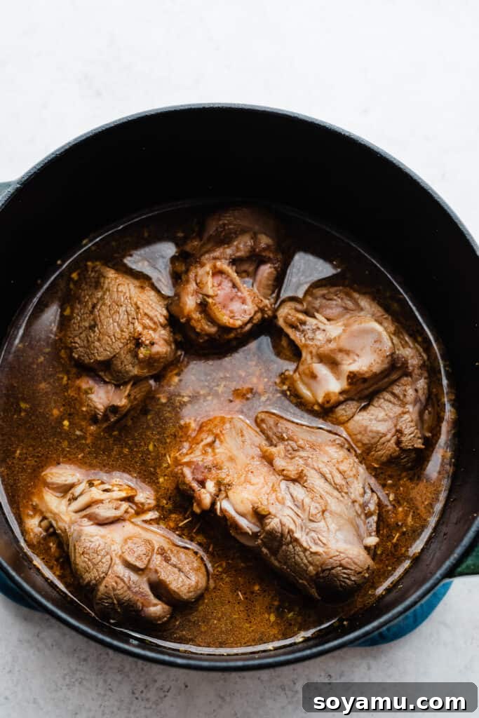 Melt-in-Your-Mouth One-Pot Lamb Barbacoa Tacos 5 Seared lamb meat in a dutch oven, surrounded by the aromatic marinade, ready for braising.
