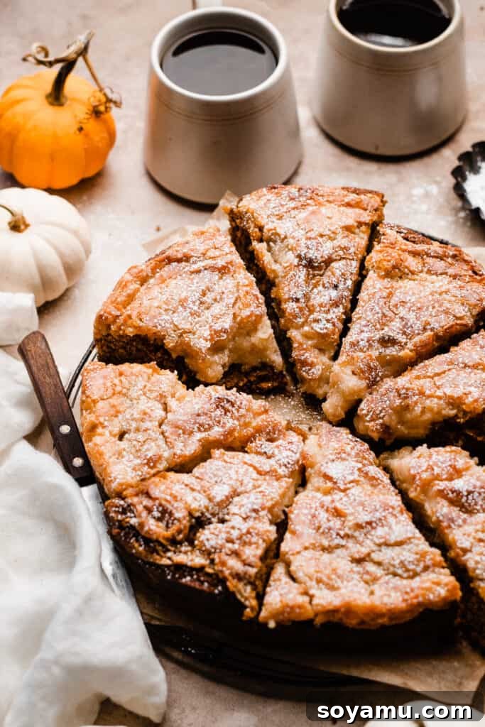 Decadent Pumpkin Gooey Butter Cake 3 Pumpkin gooey butter cake slices arranged neatly on a wire cooling rack, lightly dusted with powdered sugar.