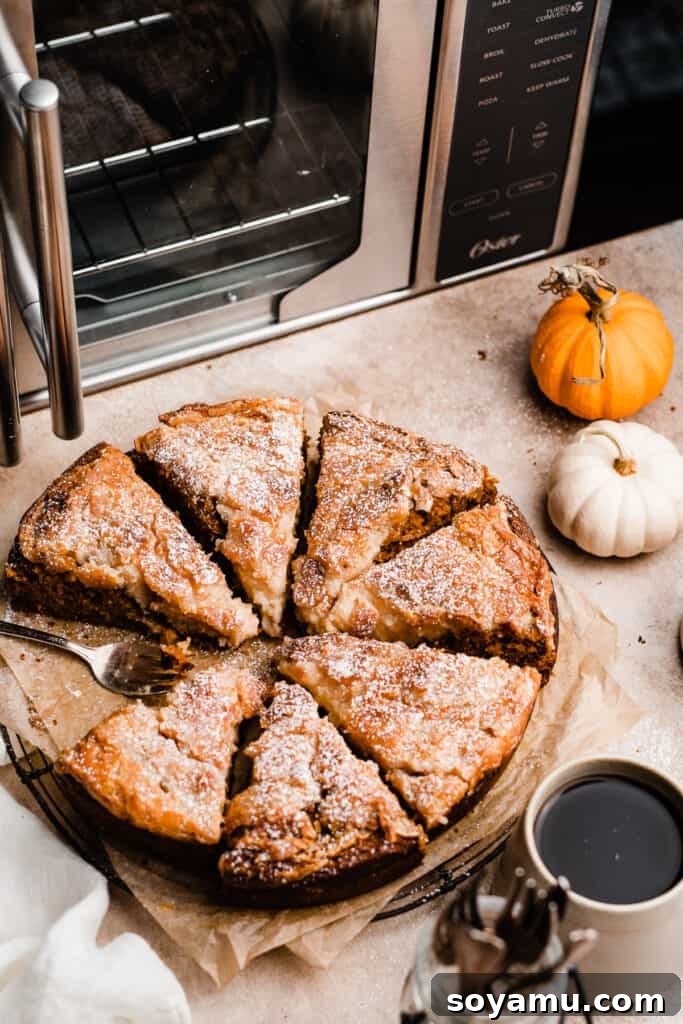 Decadent Pumpkin Gooey Butter Cake 9 Slices of pumpkin gooey butter cake beautifully arranged with an air fry oven visible in the softly blurred background, hinting at the baking process.