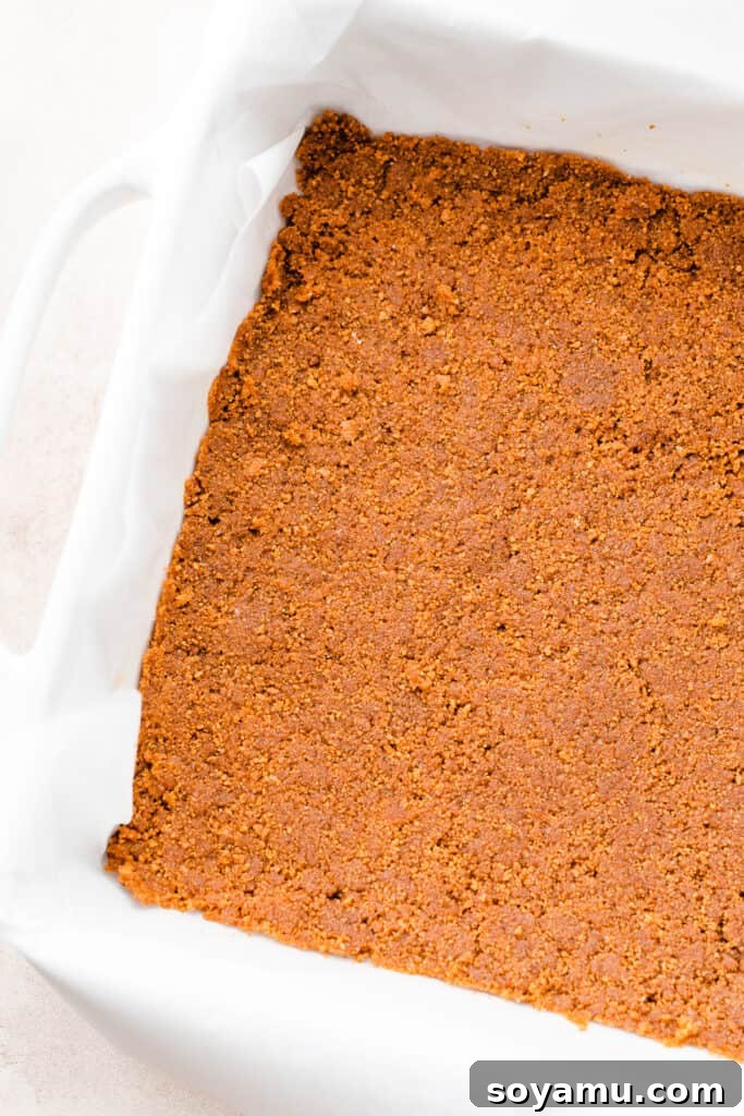 Velvet Pumpkin Irish Cream Cheesecake Bars 4 A close-up of the perfectly baked gingersnap cookie crust in a 9x9 inch baking pan, golden brown and ready for the cheesecake filling.