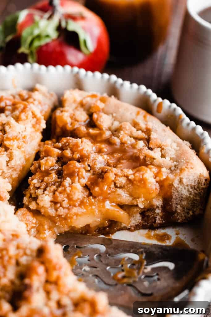 Decadent Caramel Apple Streusel Pizza 8 A close-up on the baked caramel apple dessert pizza, highlighting the caramelized apple slices and golden cinnamon streusel.