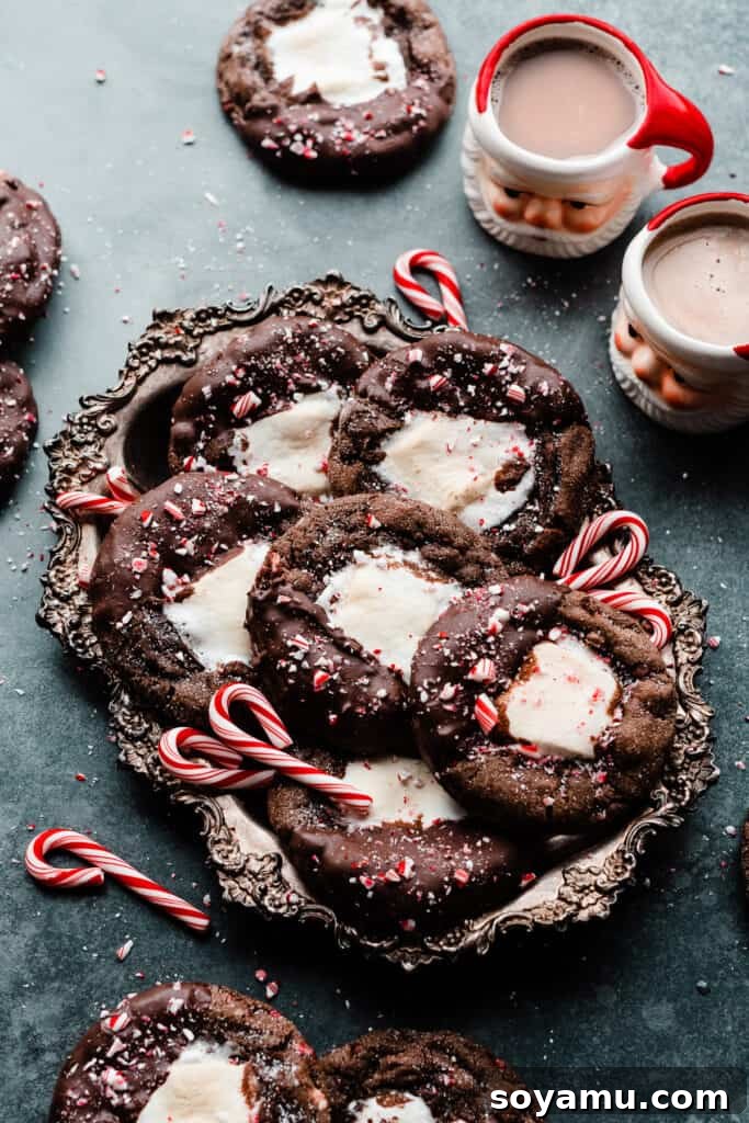A vintage tray showcasing the chocolate marshmallow cookies on a slate surface, accompanied by festive Santa hot cocoa mugs, setting a cozy holiday scene.
