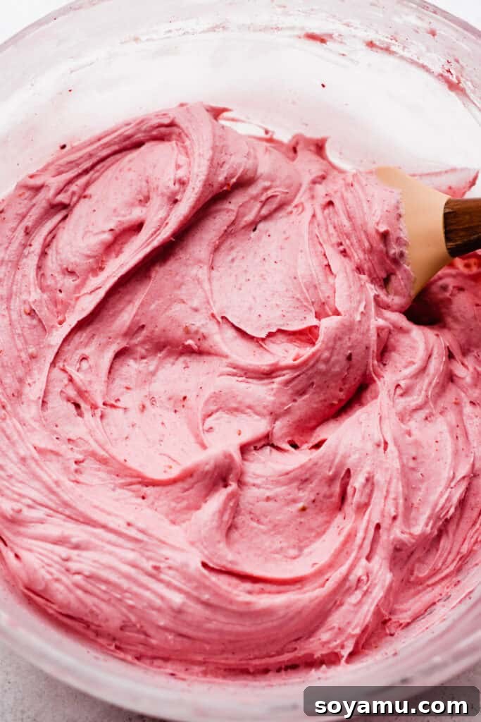 Pink Champagne Raspberry Delights 6 A bowl of vibrant pink raspberry frosting, rich and creamy, ready to adorn the cupcakes.