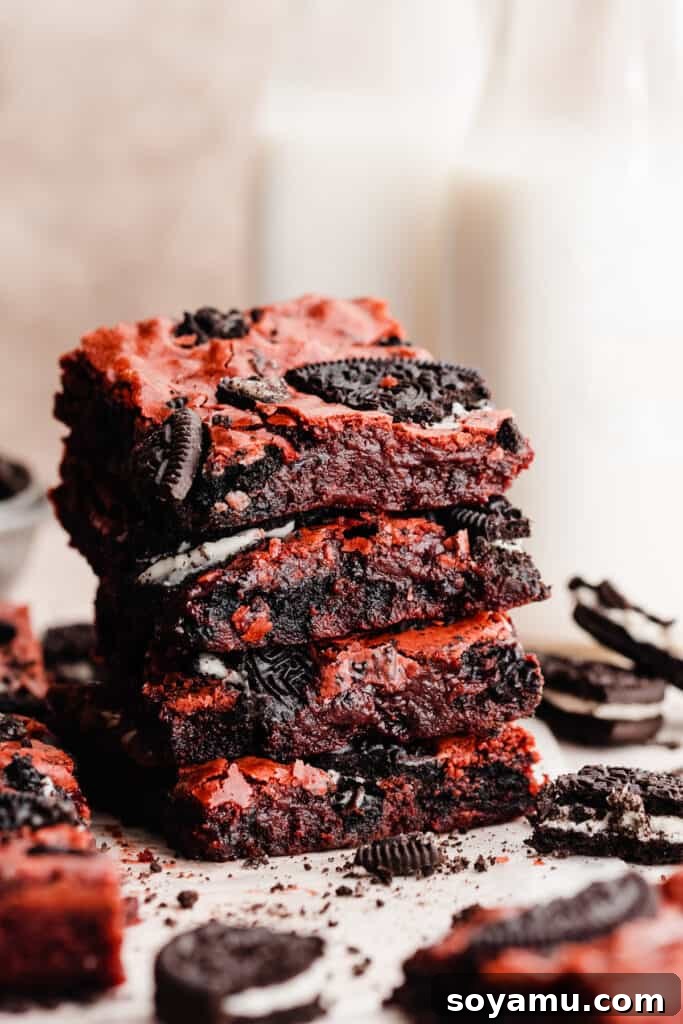 Velvet Swirl Oreo Fudge Brownies 6 A stack of red velvet brownies with milk bottles in the background.