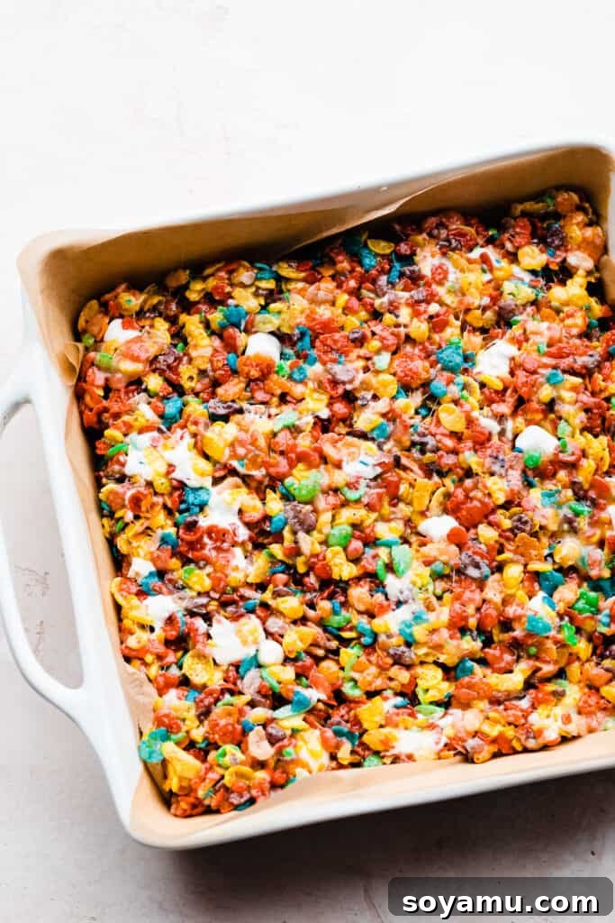 A baking pan filled with the pressed Fruity Pebbles treats, cooling before the glaze is applied.