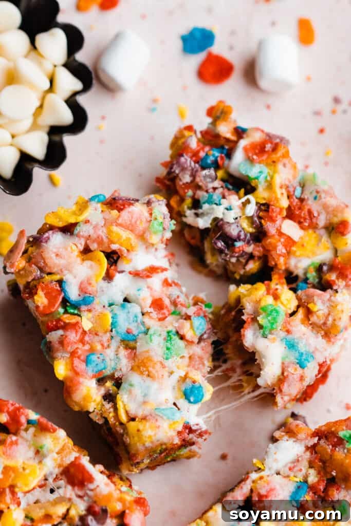 A Fruity Pebbles treat being pulled apart, revealing its incredibly gooey and stretchy marshmallow interior.