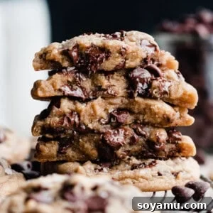 A stack of cookie halves, showing their gooey insides with melty chocolate chips.