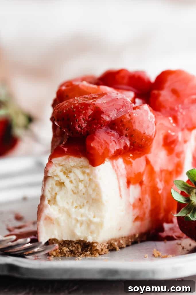 Easy 10-Minute Strawberry Compote 3 A delectable close-up of a slice of creamy cheesecake generously topped with vibrant strawberry compote, highlighting the fresh berry pieces.
