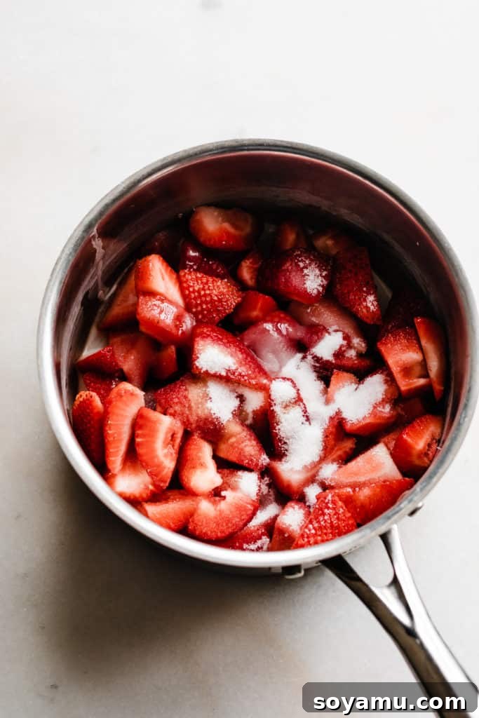 Easy 10-Minute Strawberry Compote 4 A medium saucepan on the stove filled with fresh strawberries and granulated sugar, ready to be cooked into a compote.