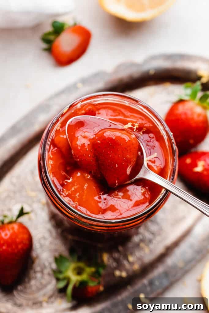 Easy 10-Minute Strawberry Compote 7 A charming jar of strawberry topping, rich and glossy, presented on a vintage metal tray, ready to be served.