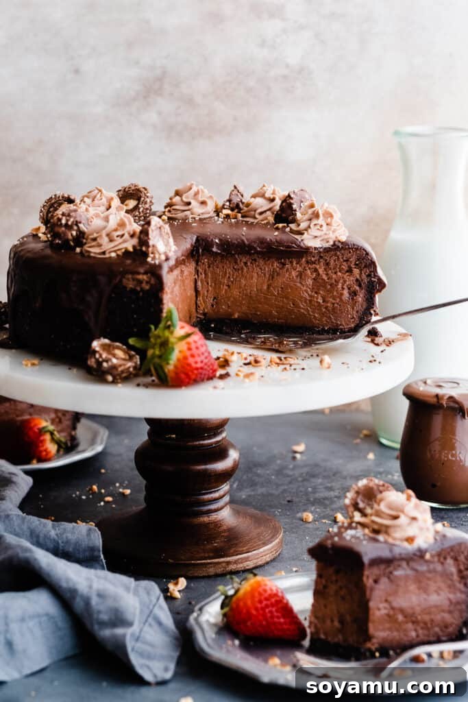 Slices of cheesecake on plates with the sliced cheesecake on a cake stand, adorned with ganache and cream.