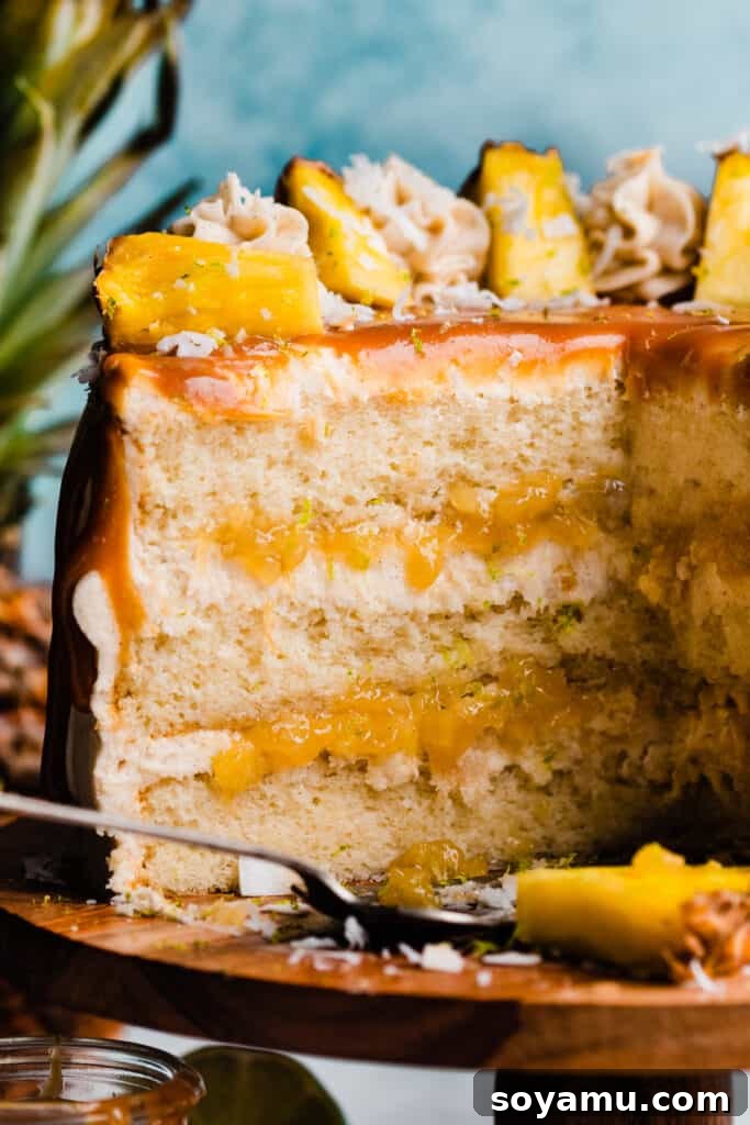 Piña Colada Dream Cake 2 A close-up on the inside of the pina colada cake, with layers of cake, frosting, and pineapple filling visible.