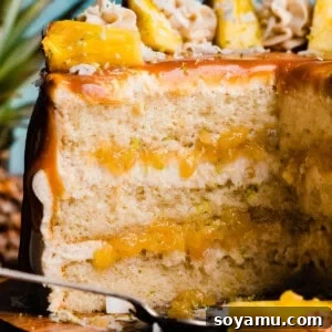 Piña Colada Dream Cake 14 A close-up on the sliced pina colada cake, with coconut frosting and pineapple filling showing.