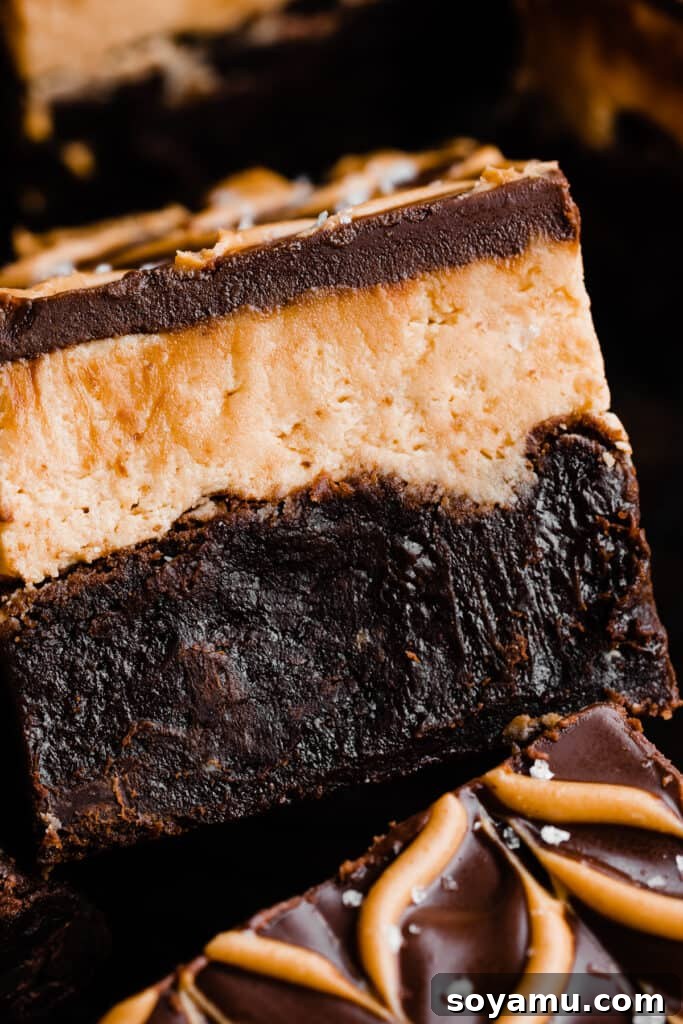 Buckeye Bliss Brownies 9 A close-up, mouth-watering shot of a Buckeye brownie slice, revealing its distinct fudgy brownie, creamy peanut butter, and rich chocolate layers.