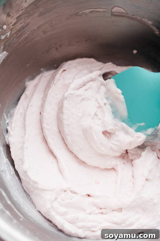 Zingy Raspberry Lemon Cloud Cheesecake 10 A bowl of freshly made raspberry whipped cream, light pink and fluffy, ready to adorn the cheesecake.