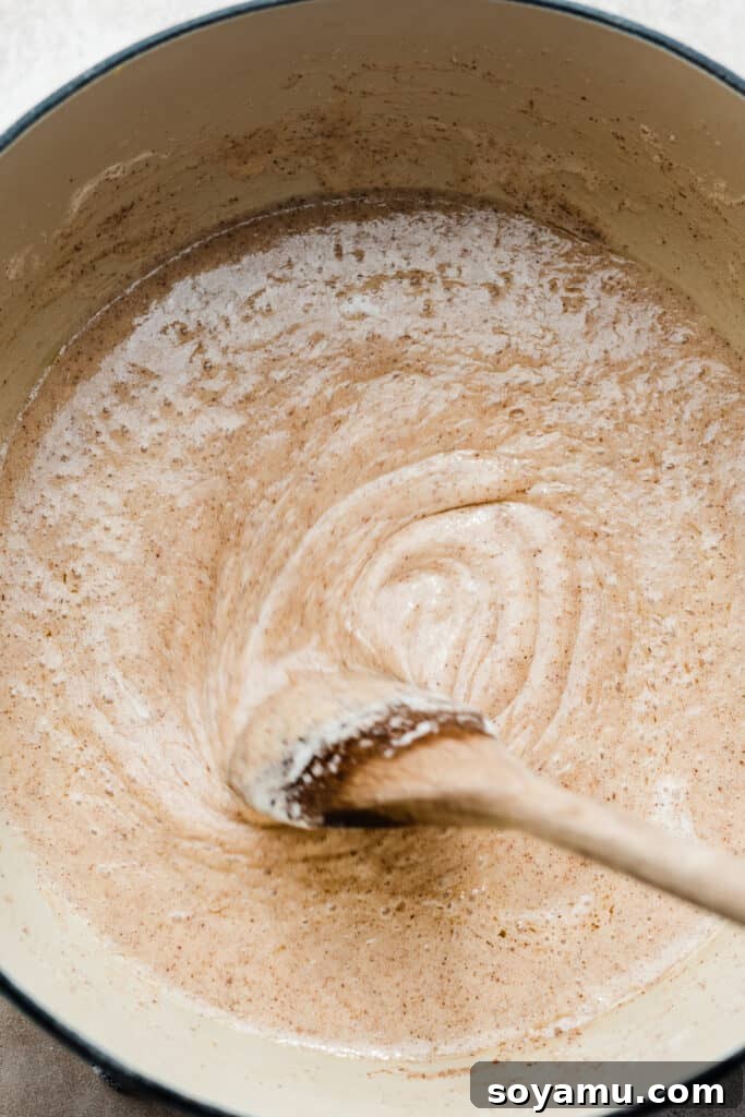 The melted butter and marshmallow mixture being stirred in a pot, creating a smooth, gooey base.